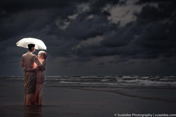 bride groom hugging beach umbrella night onelight