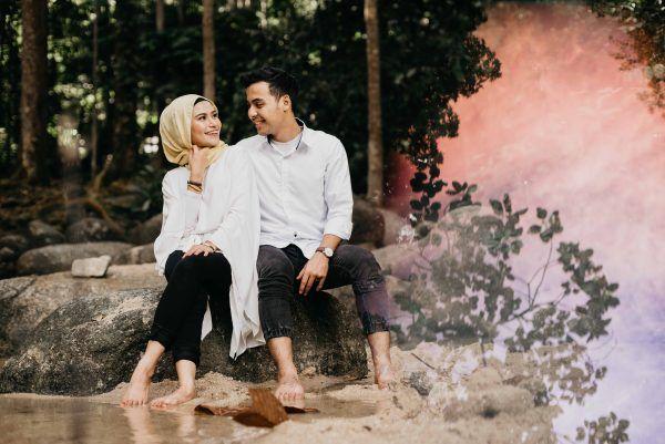 couple sitting rock river love reflection