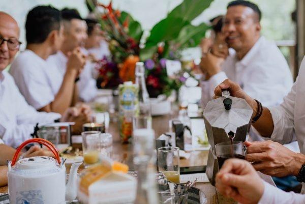 pouring coffee with guest in the background